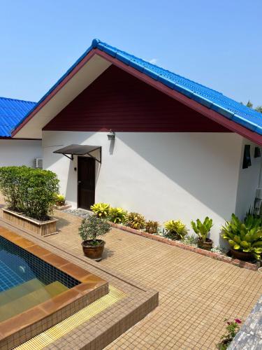 a house with a swimming pool next to a house at Sawasdee Home Stay Resort & Pool in Khao Lak