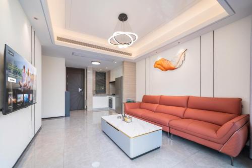 a living room with a red couch and a table at Puhai Sea View Apt by Hailan Tour at Sanya Yazhou Bay#only 100 meters to Beach and Sea Swimming Area in Sanya