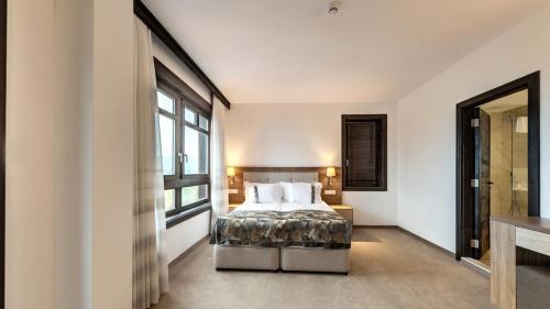 a bedroom with a bed and a large window at Wine & Spa Complex Starosel in Starosel