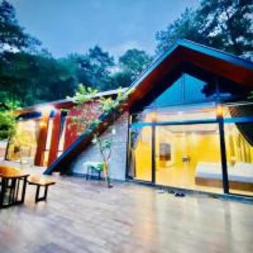a small house with a large window on a patio at SH Homestay - Venuestay in Sóc Sơn