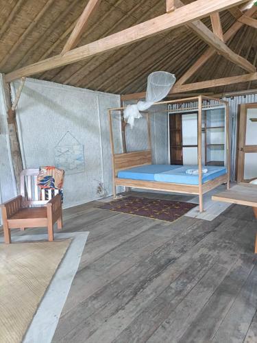 a room with a bunk bed and a chair at Sunrise Villa in Maluk