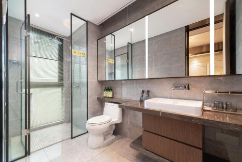 a bathroom with a toilet and a sink and a shower at Puhai Sea View Apt by Hailan Tour at Sanya Yazhou Bay#only 100 meters to Beach and Sea Swimming Area in Sanya