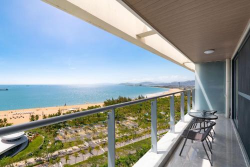 a balcony with chairs and a view of the beach at Puhai Sea View Apt by Hailan Tour at Sanya Yazhou Bay#only 100 meters to Beach and Sea Swimming Area in Sanya