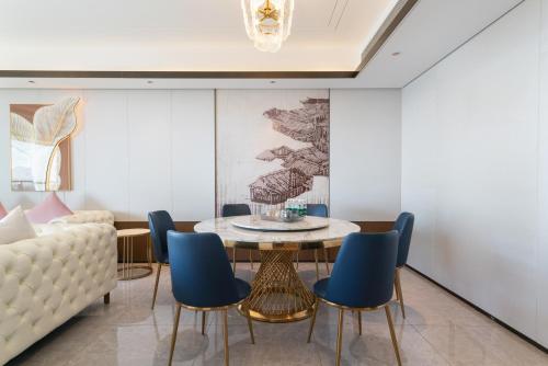 a living room with a table and chairs at Puhai Sea View Apt by Hailan Tour at Sanya Yazhou Bay#only 100 meters to Beach and Sea Swimming Area in Sanya