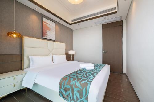 a bedroom with a large white bed in a room at Puhai Sea View Apt by Hailan Tour at Sanya Yazhou Bay#only 100 meters to Beach and Sea Swimming Area in Sanya
