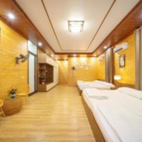 a room with a row of white beds in it at SH Homestay - Venuestay in Sóc Sơn