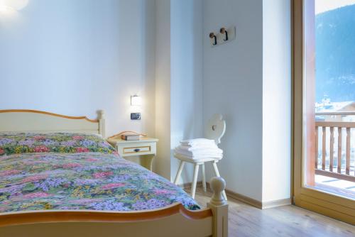 a bedroom with a bed and a table and a window at Hotel La Nuova Montanina in Auronzo di Cadore