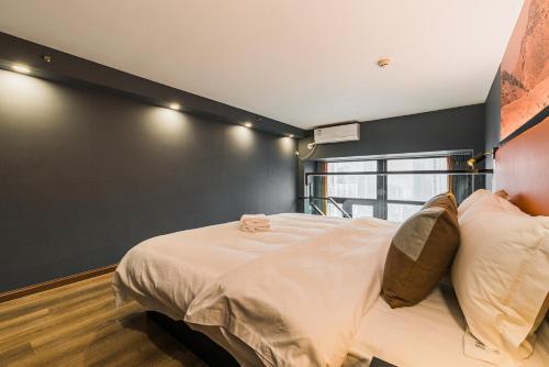 a bedroom with a large white bed with a black wall at 云享城居 SKY高空Loft公寓酒店 春熙路九眼桥店 in Chengdu