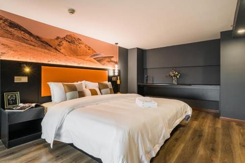 a bedroom with a large white bed with an orange headboard at 云享城居 SKY高空Loft公寓酒店 春熙路九眼桥店 in Chengdu