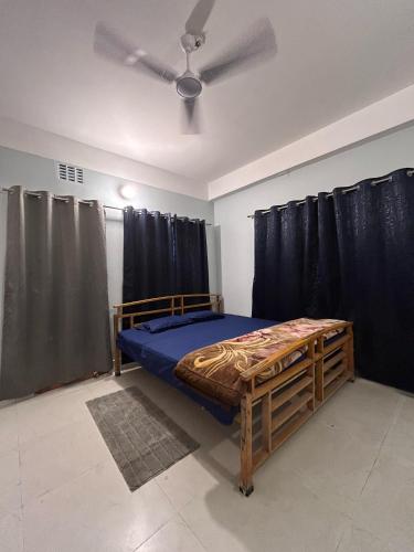 a bedroom with a bed and a ceiling fan at Cozy Third-Floor Room w Balcony in Siliguri