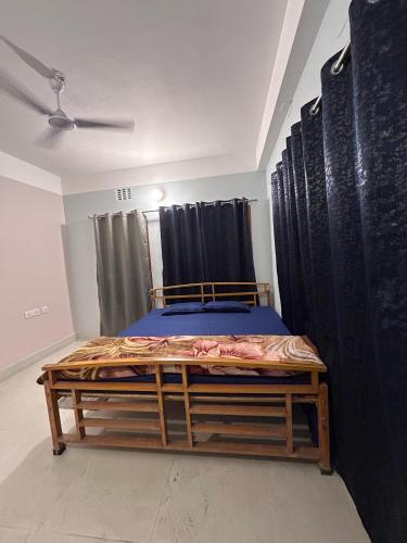 a bed in a room with black curtains at Cozy Third-Floor Room w Balcony in Siliguri