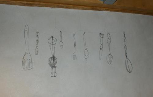a bunch of utensils hanging on a wall at Mas de la Borie -Chambre d'hôtes in Joannas