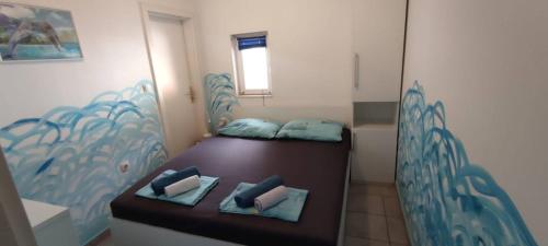 a small room with two beds with blue pillows at Apartments Luna in Žuljana
