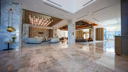 a lobby with a large room with tables and chairs at Durrat Jalmouda Hotel in Al Jubail