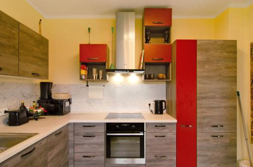 a kitchen with red cabinets and a stove top oven at Haus unterm Räuschenberg in Höxter