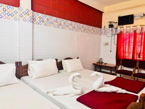 two swans made out of towels sit on a bed at shree katyayani residency in Gokarna