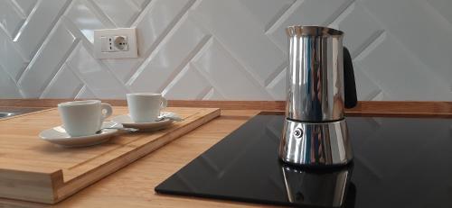 a coffee machine sitting on a table with two cups at Canaletto apartment con parcheggio in Dolo
