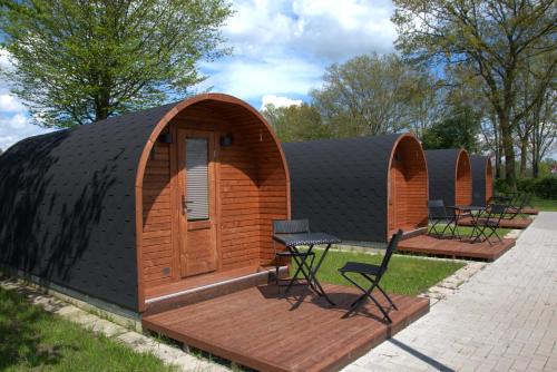 a small building with a wooden door and a patio at Campingpod in Südbrookmerland