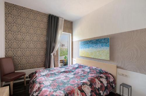 a bedroom with a bed and a chair and a painting at Ferienwohnung 'an der Ostsee' in Mechelsdorf