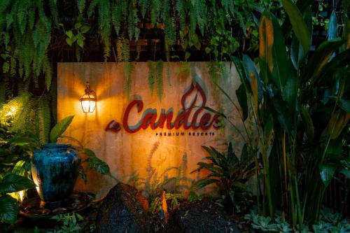 a sign for a cannzyme sign in a garden at Le Candles Resort in Kozhikode
