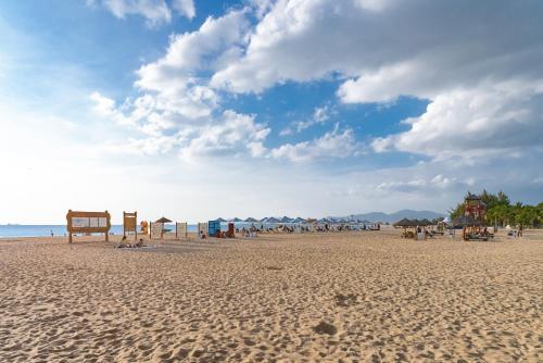 a beach with a group of people and the ocean at Puhai Sea View Apt by Hailan Tour at Sanya Yazhou Bay#only 100 meters to Beach and Sea Swimming Area in Sanya