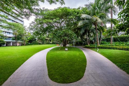 a walkway in a park with trees and grass at Puhai Sea View Apt by Hailan Tour at Sanya Yazhou Bay#only 100 meters to Beach and Sea Swimming Area in Sanya