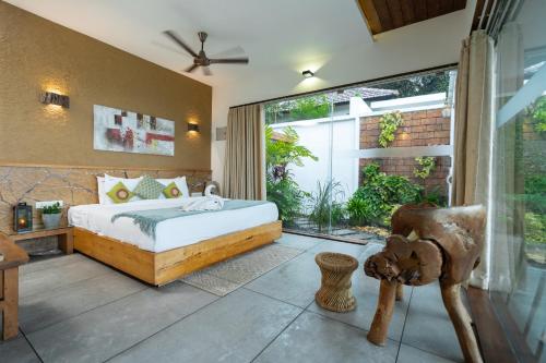 a bedroom with a bed and a large window at Le Candles Resort in Kozhikode