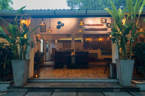 a patio with potted plants in front of a restaurant at Le Candles Resort in Kozhikode