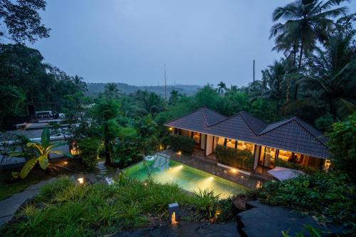 an aerial view of a house with a swimming pool at Le Candles Resort in Kozhikode