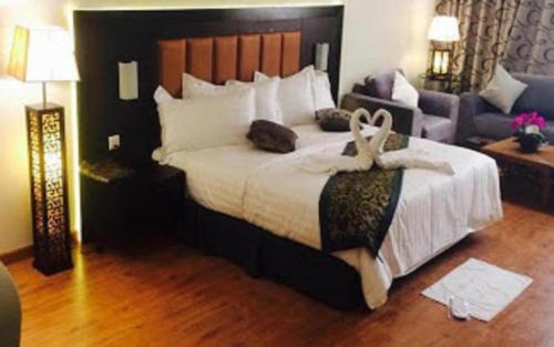 a bedroom with a large bed and a couch at Dancenter Luxury Millennia Near King Abdulaziz Historical Center in Riyadh