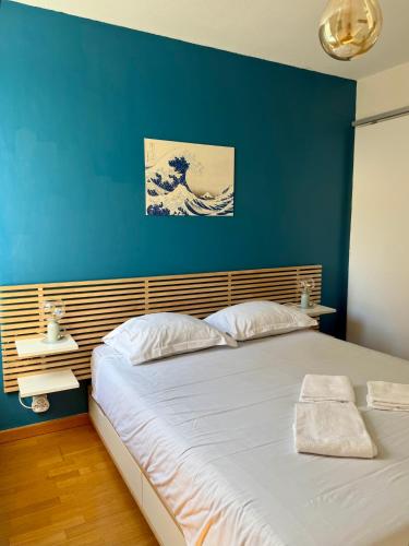 une chambre avec un grand lit avec un mur bleu dans l'établissement T2 au cœur du quartier Saint-Cyprien à Toulouse, à Toulouse