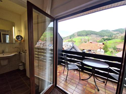 a bathroom with a balcony with a table and a sink at Mosers Blume Relax & Genuss Hotel in Haslach im Kinzigtal