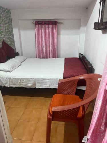 a small room with a bed and a chair at Amazing Homestay in Guwahati