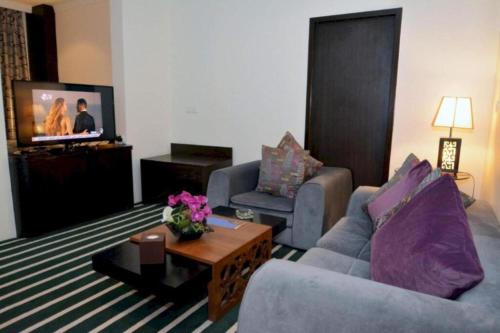 a living room with two couches and a tv at Dancenter Luxury Millennia Near King Abdulaziz Historical Center in Riyadh