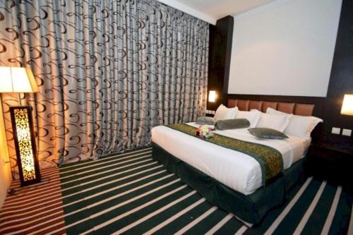 a bedroom with a bed in a room with a wall at Dancenter Luxury Millennia Near King Abdulaziz Historical Center in Riyadh
