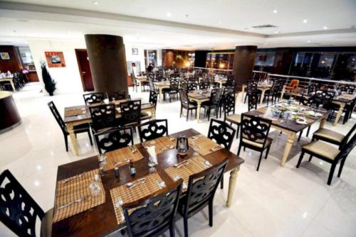 a dining room with tables and chairs in a restaurant at Dancenter Luxury Millennia Near King Abdulaziz Historical Center in Riyadh
