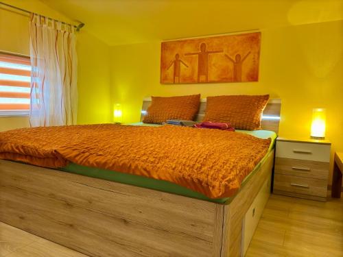 a bedroom with a large bed in a yellow room at Ferienhaus An der Riede in Bedekaspel