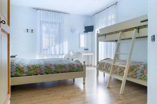 a bedroom with two bunk beds and a television at Hotel La Nuova Montanina in Auronzo di Cadore
