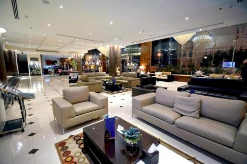 a large lobby with couches and chairs in a building at Dancenter Luxury Millennia Near King Abdulaziz Historical Center in Riyadh