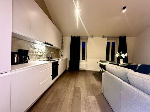a kitchen with white cabinets and a couch at Luxury Suites Princess by Rikas Hotels in Antwerp