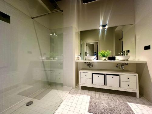 a bathroom with a shower and a sink and a mirror at Luxury Suites Princess by Rikas Hotels in Antwerp