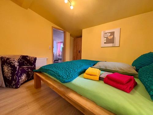 a bed with colorful blankets on it in a room at Ferienhaus An der Riede in Bedekaspel