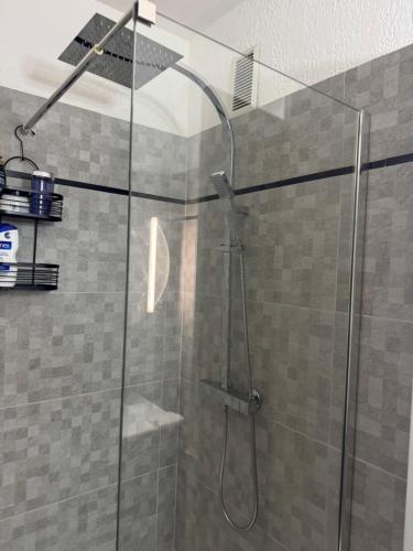 une douche avec une porte vitrée dans une salle de bain dans l'établissement Les palmiers, à Cavalaire-sur-Mer