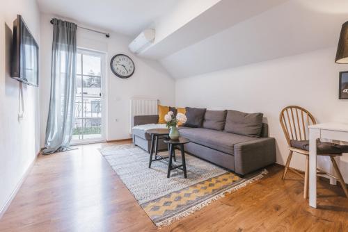 a living room with a couch and a clock on the wall at Apartment Vila Pavlovski in Bled