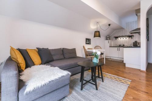 a living room with a gray couch and a table at Apartment Vila Pavlovski in Bled
