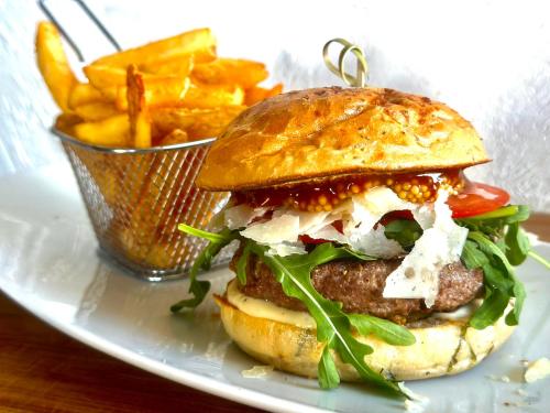 a sandwich on a plate with a basket of fries at Jägerhof Putzkau in Putzkau