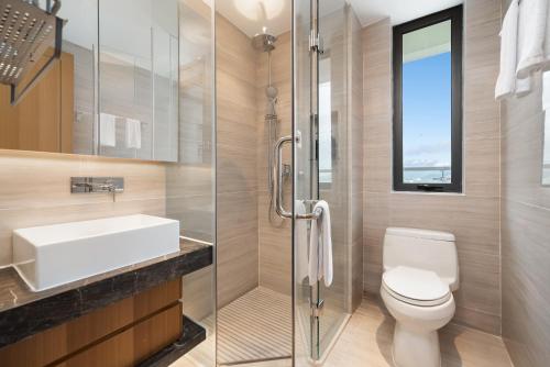 a bathroom with a toilet and a sink and a shower at Puhai Sea View Apt by Hailan Tour at Sanya Yazhou Bay#only 100 meters to Beach and Sea Swimming Area in Sanya