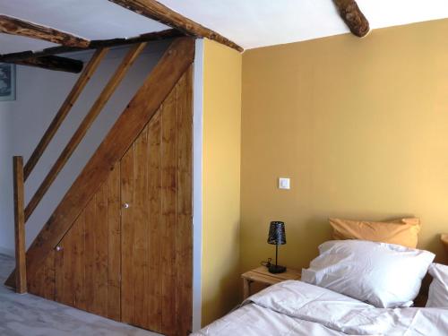 a bedroom with a wooden sliding barn door at Mas de la Borie -Chambre d'hôtes in Joannas
