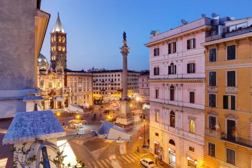 een uitzicht op een stad in de nacht met een klokkentoren bij Hotel Amalfi in Rome