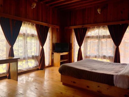 a bedroom with a bed and two large windows at Risum Resort in Ha